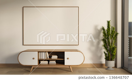 White frame on wall over bookshelf drawer table and pot plant on wooden parquet floor in modern room 136648707