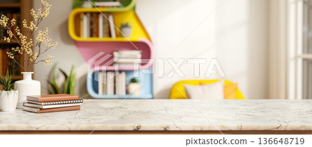Books and flower vase on marble counter table across colorful wall bookshelf and sofa in living room 136648719