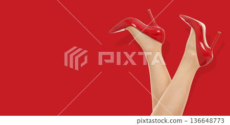 A woman shows off her red high heels with legs crossed A woman shows off her red high heels with legs crossed 136648773