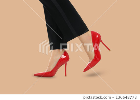 A woman displays red high heels while posing confidently 136648778