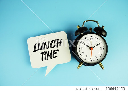 Lunch Time text on speech bubble with alarm clock on blue background Lunch Time text on speech bubble with alarm clock on blue background 136649453