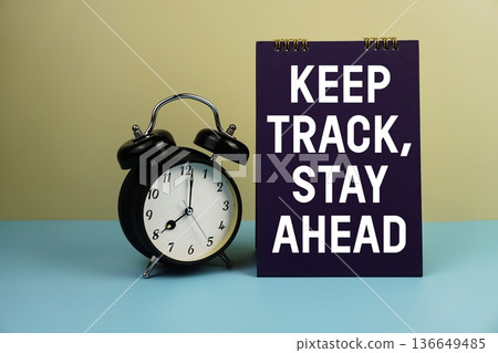 Keep Track, Stay Ahead text with alarm clock on yellow and blue background 136649485