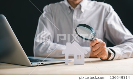 Real estate appraisal, inspector with magnifying glass on house model, searching property for home valuation, performing thorough inspection analysis using laptop technology Real estate appraisal, inspector with magnifying glass on house model, searching property for home valuation, performing thorough inspection analysis using laptop technology 136649514