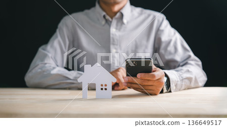 Person holds smart phone for home real estate property search, exploring detailed house information online with mobile app, planning new investment for future dreams 136649517
