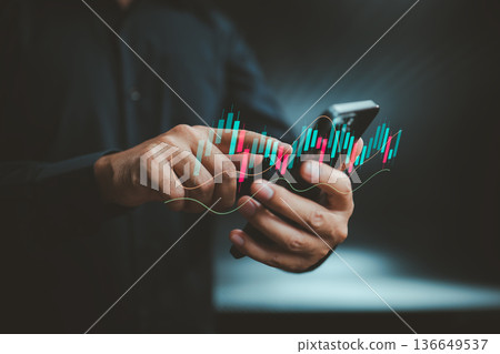 Person using smartphone with digital stock market candlestick chart overlay Person using smartphone with digital stock market candlestick chart overlay 136649537