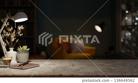 Books and coffee under lamp light on marble stone counter table across sofa chair in a dim lit room. 136649562