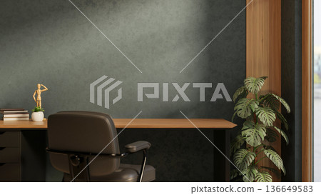 Books and figure on wooden table with leather chair and houseplant aside dark green wall in a room. 136649583