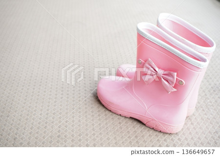 Pink children's rain boots placed on a pale background Lifestyle image Pink children's rain boots placed on a pale background Lifestyle image 136649657