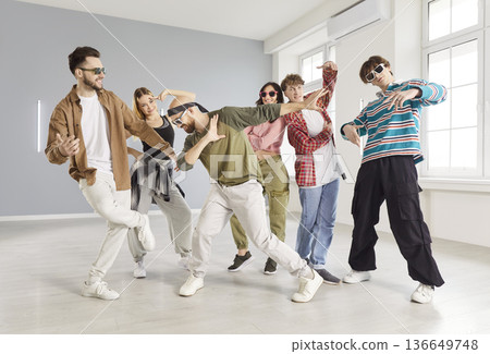 Energetic young women and men friends being professional dancers, preparing for performance Energetic young women and men friends being professional dancers, preparing for performance 136649748