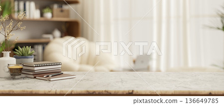 Coffee cup and books on marble counter table across white sofa and wooden bookshelf in a living room 136649785