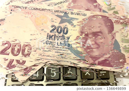 Turkish Lira and Calculator Finance Concept. 200 TRY banknotes on calculator representing Turkish economy, budgeting, and financial planning. 200 Turkish Lira banknotes placed on a black calculator. Turkish Lira and Calculator Finance Concept. 200 TRY banknotes on calculator representing Turkish economy, budgeting, and financial planning. 200 Turkish Lira banknotes placed on a black calculator. 136649899