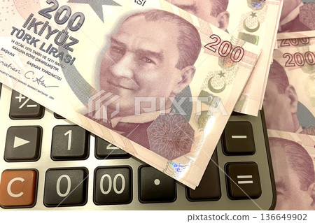 Turkish Lira and Calculator Finance Concept. 200 TRY banknotes on calculator representing Turkish economy, budgeting, and financial planning. 200 Turkish Lira banknotes placed on a black calculator. Turkish Lira and Calculator Finance Concept. 200 TRY banknotes on calculator representing Turkish economy, budgeting, and financial planning. 200 Turkish Lira banknotes placed on a black calculator. 136649902