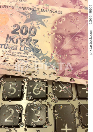 Turkish Lira and Calculator Finance Concept. 200 TRY banknotes on calculator representing Turkish economy, budgeting, and financial planning. 200 Turkish Lira banknotes placed on a black calculator. Turkish Lira and Calculator Finance Concept. 200 TRY banknotes on calculator representing Turkish economy, budgeting, and financial planning. 200 Turkish Lira banknotes placed on a black calculator. 136649905