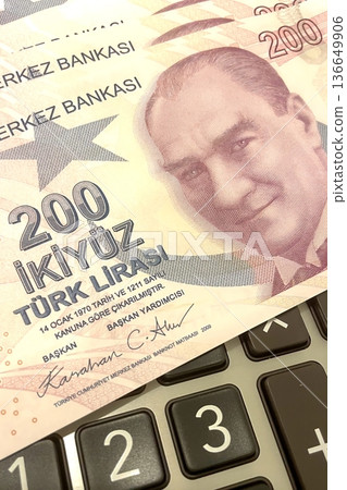 Turkish Lira and Calculator Finance Concept. 200 TRY banknotes on calculator representing Turkish economy, budgeting, and financial planning. 200 Turkish Lira banknotes placed on a black calculator. Turkish Lira and Calculator Finance Concept. 200 TRY banknotes on calculator representing Turkish economy, budgeting, and financial planning. 200 Turkish Lira banknotes placed on a black calculator. 136649906
