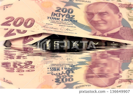 Turkish Lira and Calculator Finance Concept. 200 TRY banknotes on calculator representing Turkish economy, budgeting, and financial planning. 200 Turkish Lira banknotes placed on a black calculator. Turkish Lira and Calculator Finance Concept. 200 TRY banknotes on calculator representing Turkish economy, budgeting, and financial planning. 200 Turkish Lira banknotes placed on a black calculator. 136649907