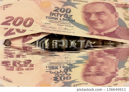 Turkish Lira and Calculator Finance Concept. 200 TRY banknotes on calculator representing Turkish economy, budgeting, and financial planning. 200 Turkish Lira banknotes placed on a black calculator. Turkish Lira and Calculator Finance Concept. 200 TRY banknotes on calculator representing Turkish economy, budgeting, and financial planning. 200 Turkish Lira banknotes placed on a black calculator. 136649911
