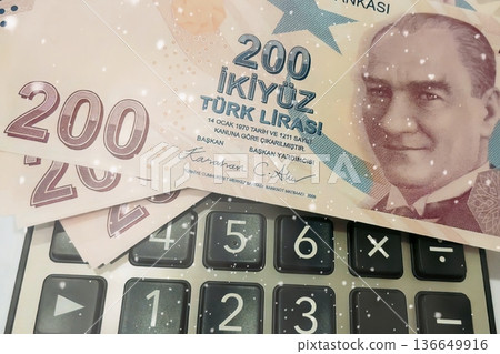 Turkish Lira and Calculator Finance Concept. 200 TRY banknotes on calculator representing Turkish economy, budgeting, and financial planning. 200 Turkish Lira banknotes placed on a black calculator. Turkish Lira and Calculator Finance Concept. 200 TRY banknotes on calculator representing Turkish economy, budgeting, and financial planning. 200 Turkish Lira banknotes placed on a black calculator. 136649916