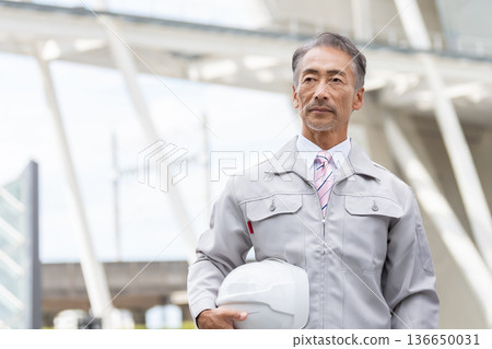 Senior male site supervisor with a helmet 136650031