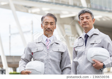 一個穿著工作服的人站在一個建築工地 136650036