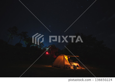 nature traveling with orange camping tent on mountain with milky way and star background nature traveling with orange camping tent on mountain with milky way and star background 136650224