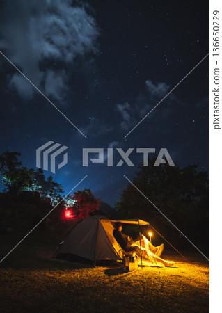 nature traveling with orange camping tent on mountain with milky way and star background nature traveling with orange camping tent on mountain with milky way and star background 136650229