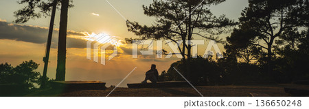 landscape and travel concept with solo traveler see sunset and twilight sky with layer of mountain 136650248