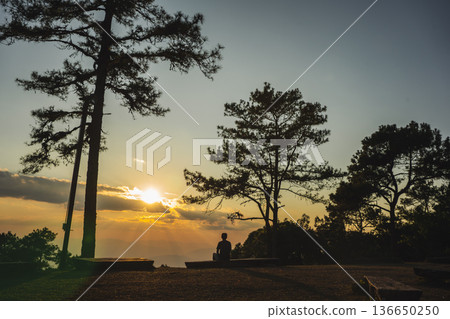 landscape and travel concept with solo traveler see sunset and twilight sky with layer of mountain landscape and travel concept with solo traveler see sunset and twilight sky with layer of mountain 136650250