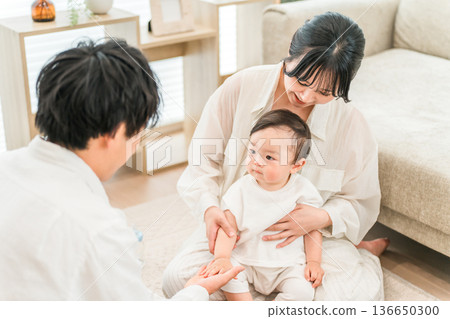 一對夫婦、家人、一位家長和孩子在客廳安撫嬰兒 一對夫婦、家人、一位家長和孩子在客廳安撫嬰兒 136650300