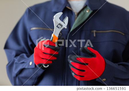 一位身穿工作服、手持工具的中年男性商人 136651591