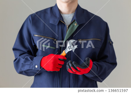 Middle-aged male businessman in work clothes holding tools Middle-aged male businessman in work clothes holding tools 136651597