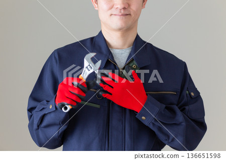 一位身穿工作服、手持工具的中年男性商人 一位身穿工作服、手持工具的中年男性商人 136651598