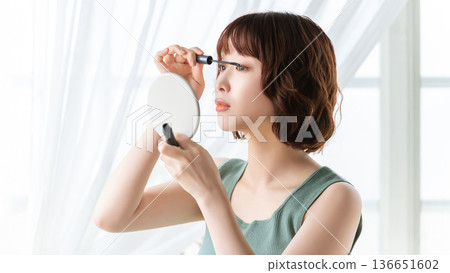 Woman applying eye makeup/beauty image 136651602