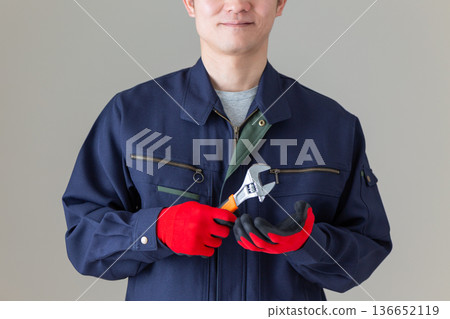 一位身穿工作服、手持工具的中年男性商人 136652119