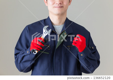 一位身穿工作服、手持工具的中年男性商人 136652120