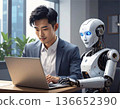 A man and a robot working on a laptop in an office. AI, digitalization, future business environment and technology 136652390