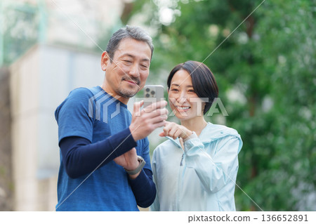 使用智慧型裝置運動的男士和女士 136652891