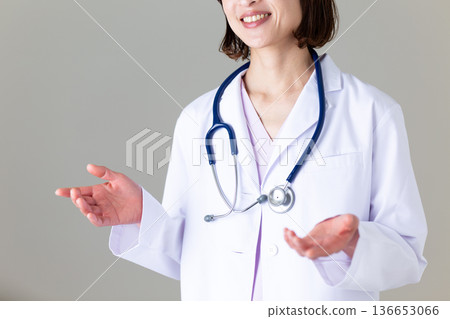 Middle-aged female nurse in a white coat Middle-aged female nurse in a white coat 136653066