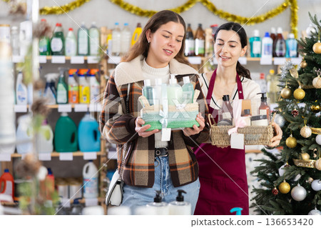 Woman seller offers cosmetics gift sets for christmas to woman buyer 136653420
