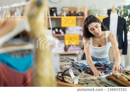 Woman in summer one chooses pants at a sale 136653581