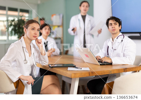 Female doctor conducts a briefing for colleagues Female doctor conducts a briefing for colleagues 136653674