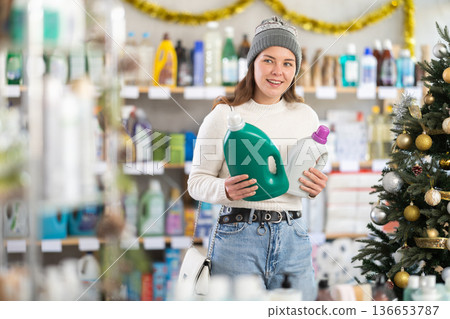Young woman choosing detergent in New Year's supermarket Young woman choosing detergent in New Year's supermarket 136653787