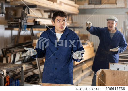 Disgruntled furniture factory owner yells at careless worker Disgruntled furniture factory owner yells at careless worker 136653788