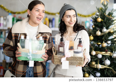 Two girls choosing gift basket in supermarket during X-mas Two girls choosing gift basket in supermarket during X-mas 136653797