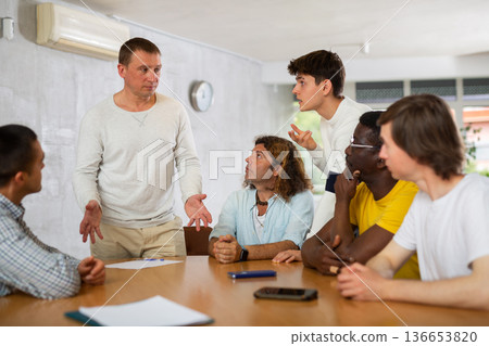 Man discussing volunteer project with group of ike-minded men Man discussing volunteer project with group of ike-minded men 136653820