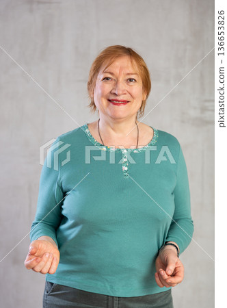Older woman standing proudly with happy confident grin Older woman standing proudly with happy confident grin 136653826