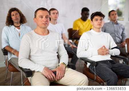 Group of men listening to lecture in auditorium attentively 136653833
