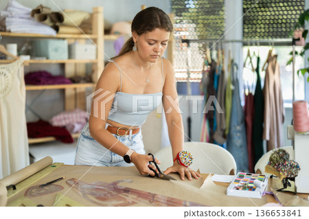 Female fashion designer cutting paper 136653841