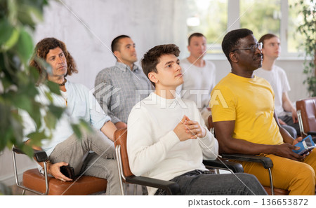 Group of men listening to lecture in auditorium attentively Group of men listening to lecture in auditorium attentively 136653872