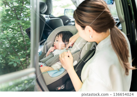 Mother putting baby in car seat Mother putting baby in car seat 136654024