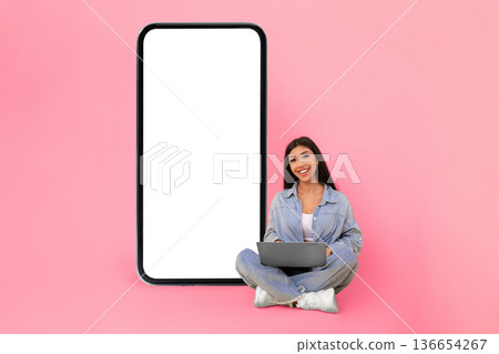 People And Technology Concept. Portrait of smiling lady using laptop computer, working or elearning remotely, sitting on floor and posing looking at camera isolated on yellow studio background wall People And Technology Concept. Portrait of smiling lady using laptop computer, working or elearning remotely, sitting on floor and posing looking at camera isolated on yellow studio background wall 136654267